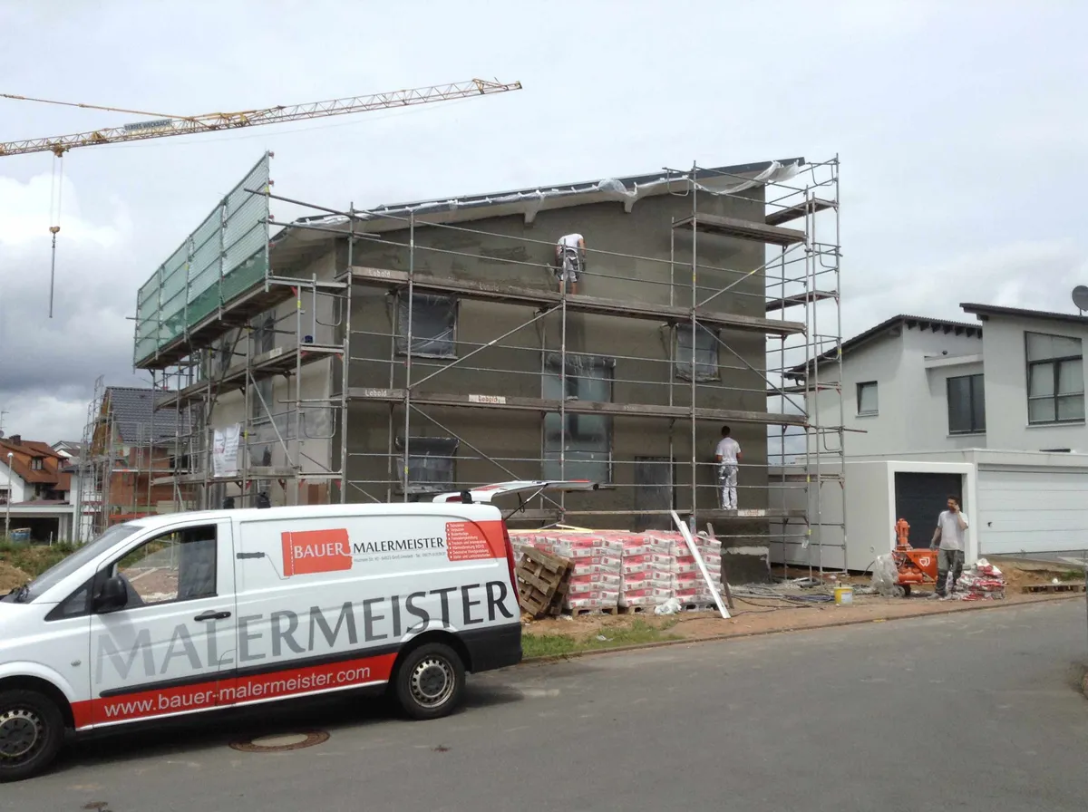 Team von Bauer Malermeister verputzt die Fassade eines Neubaus
